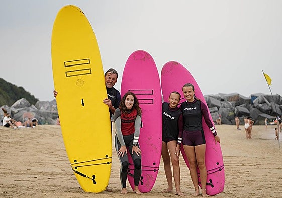 De Vries Meno y sus hijas Ana y Sofía (a la derecha) posan con las tablas de surf junto a la monitora Andrea Larretxea.