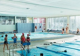 Un grupo de niñas y niños asiste a una clase de natación en las piscinas de Musakola.