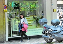 Una mujer pasa junto a la consulta de homeopatía de Pascal Trotta, el doctor que ha sido condenado en Francia, en el centro de Donostia.