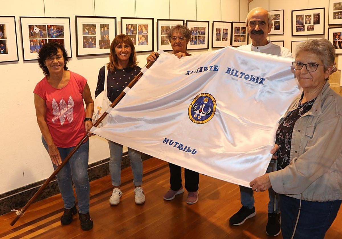 Itziar Egurbide, Josebe Illarramendi, Karmele Andonegi, Koldo Urkiza y Maite Arrizabalaga posan con la bandera de la asociación Anaiarte en la exposición habilitada para conmemorar el 25º aniversario de la tamborrada que se celebra en la localidad costera la víspera del Galbaixo Eguna.