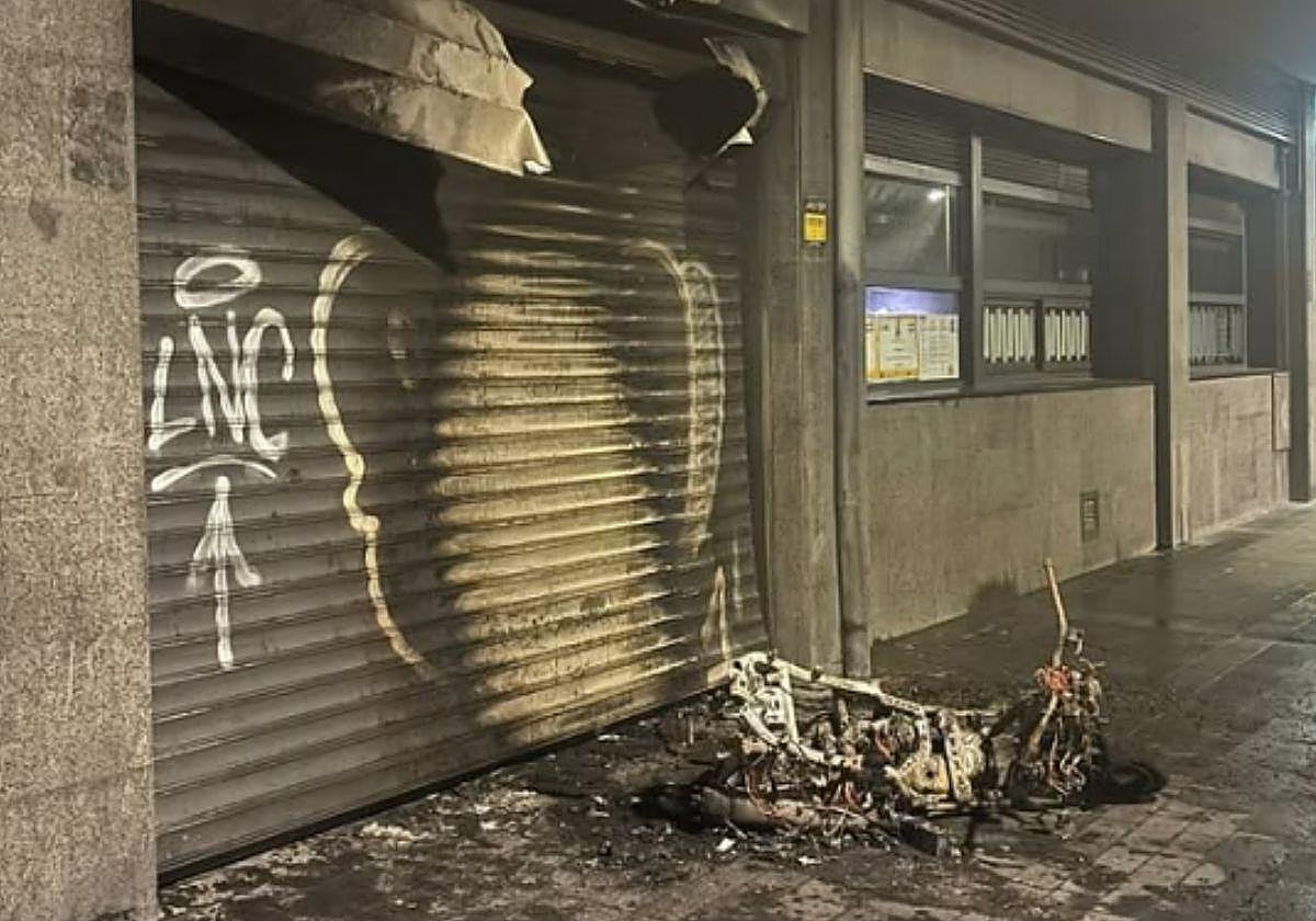 Daños provocados en el local de La Burguessia de la plaza Arroka tras prender fuego un joven a una moto junto al establecimiento.
