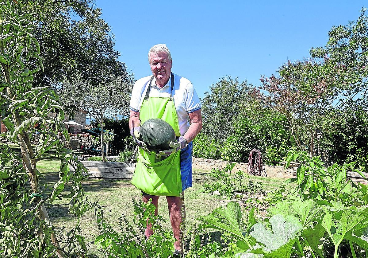 Toshack recoge una de las sandías en la huerta en la que pasa largas horas.