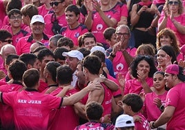 Los miembros de la marea roxa reciben a los remeros en la rampa del puerto de Donostia.