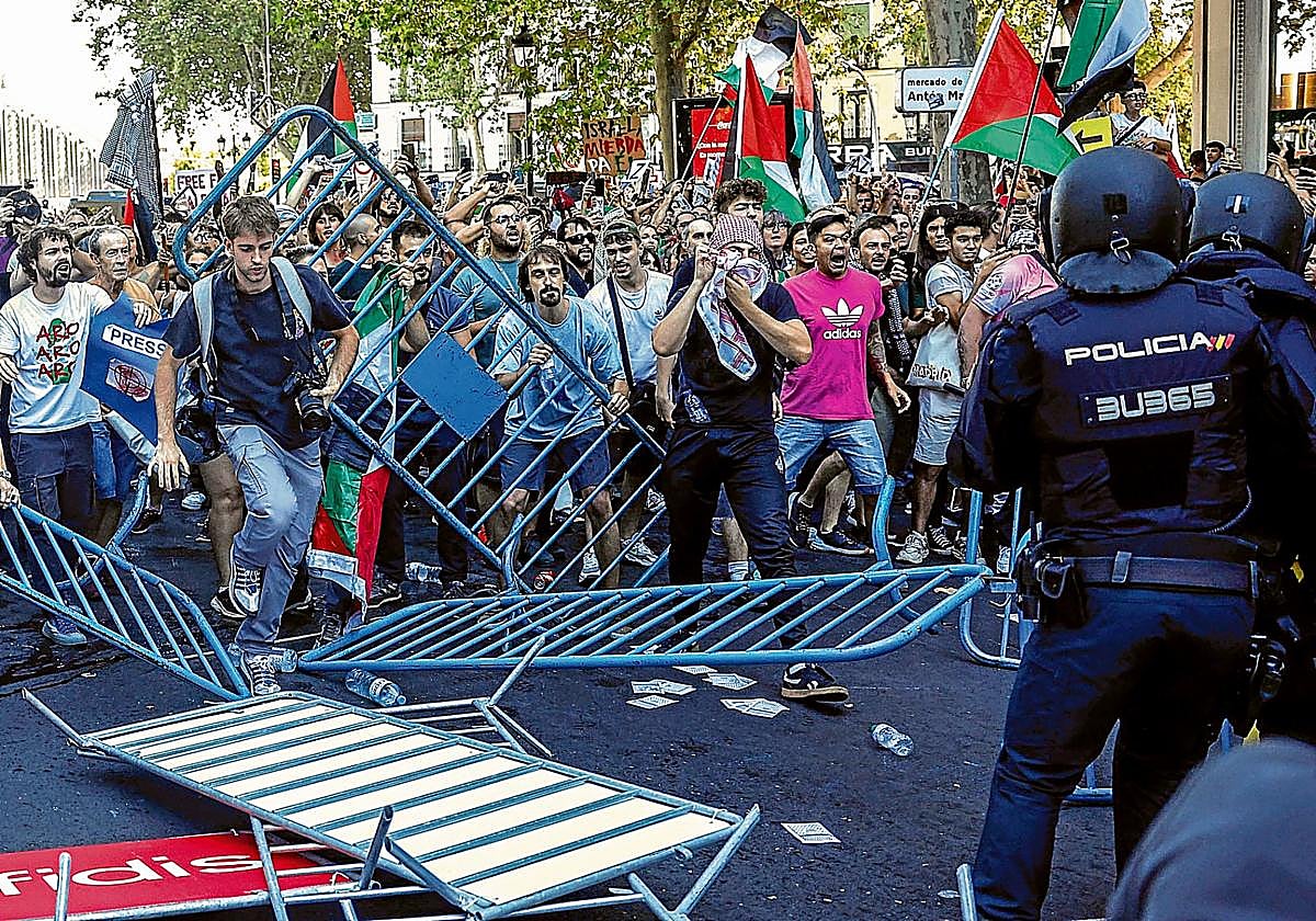 Participantes lanzan objetos contra los agentes policiales en el centro de Madrid.