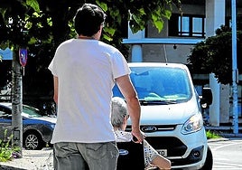 Un familiar pasea a una residente en el entorno de Txara I, en el barrio donostiarra de Intxaurrondo.