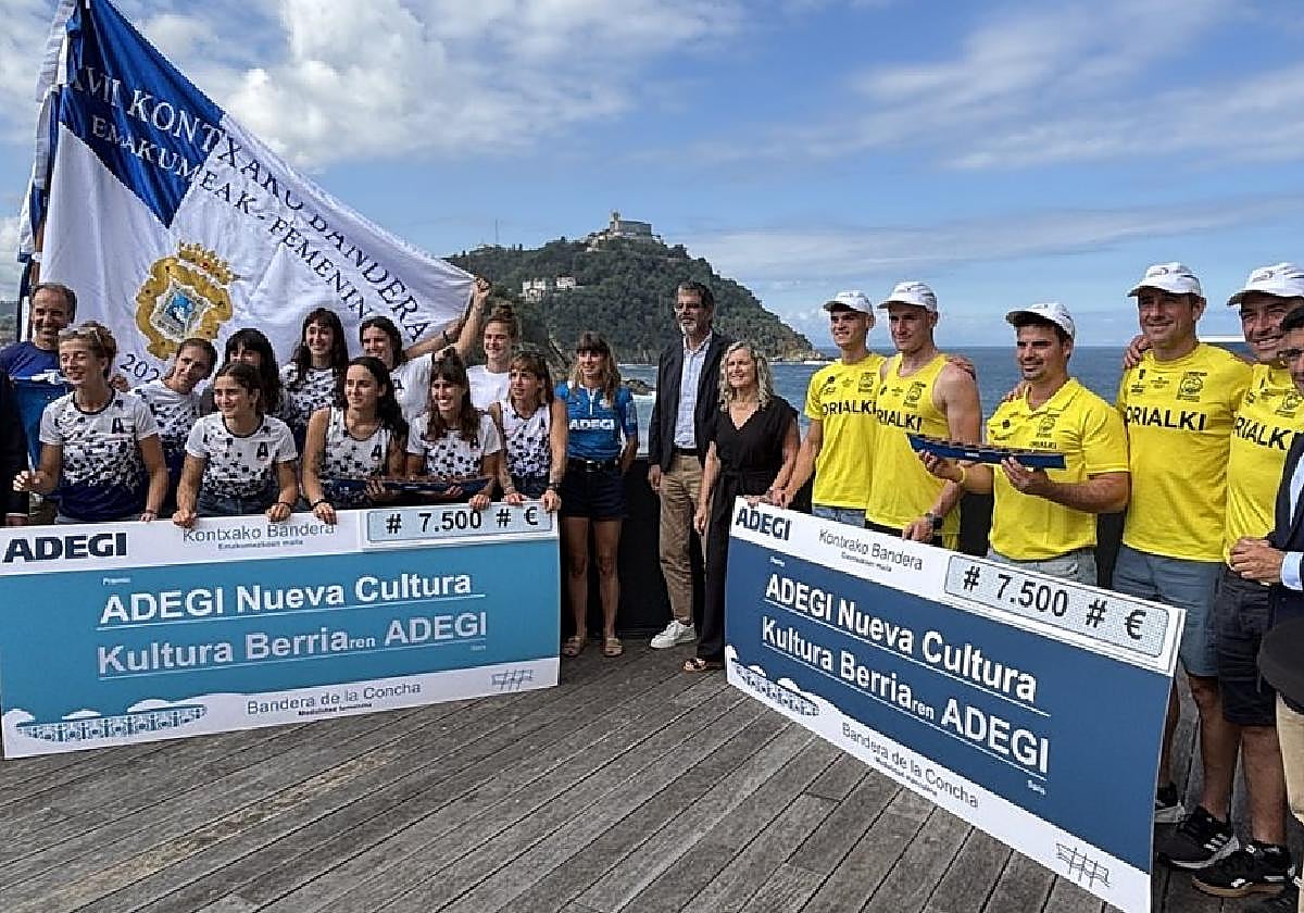 Remeras de Arraun Lagunak y remeros de Orio, con directivos de ambos clubes, el alcalde Eneko Goia y representantes de Adegi.