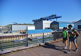 Dos personas caminan junto a Astilleros Balenciaga.