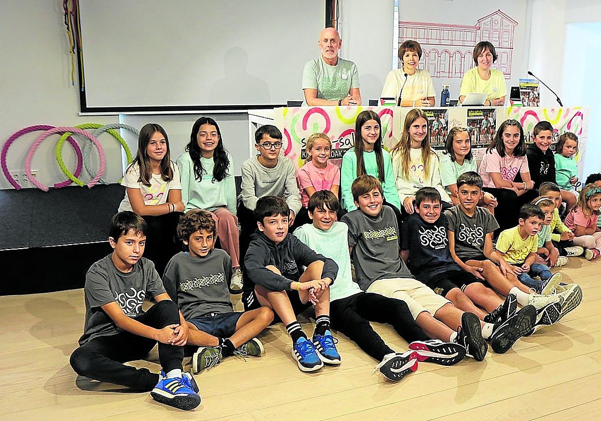 Aitor Elizaran, Olatz Astigarraga eta Iera Larrañaga atzo, Kilometroak jaiaren egitaraua aurkezten, Ikastolako hainbat haurren babesarekin.