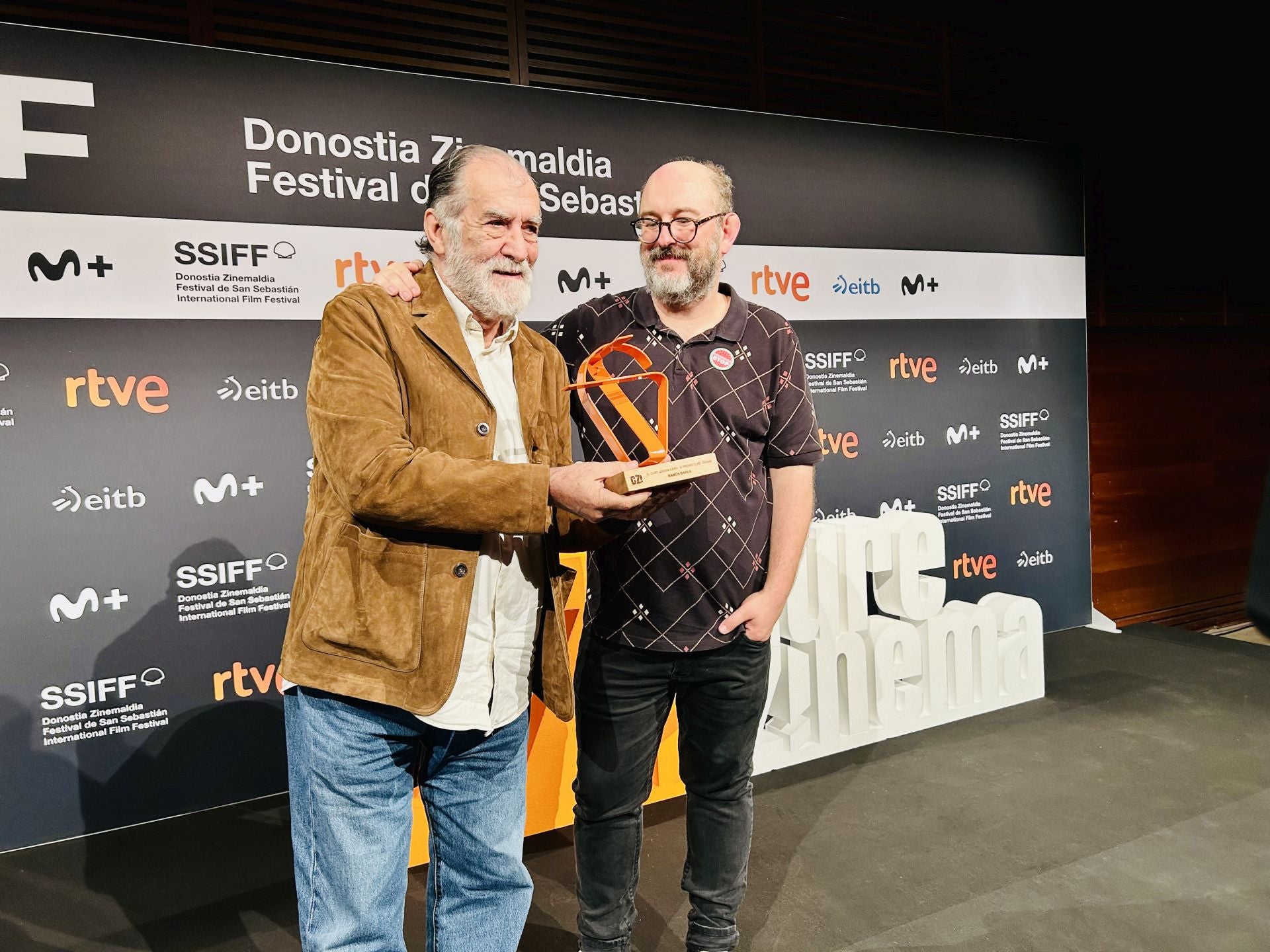 Ramón Barea recibe el Premio Gure Zinema de manos del director Borja Cobeaga en el Festival de San Sebastián.
