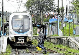 Un joven cruza el paso a nivel de Gaintxurizketa. Arriba a la derecha se ve la pasarela provisional.