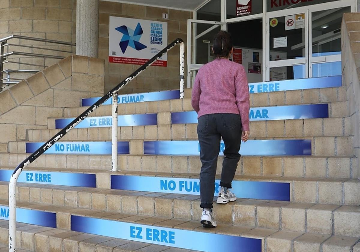 Una mujer sube las escaleras de acceso al polideportivo Olaizaga.