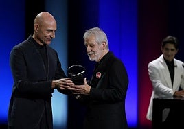 Jose Ramon Soroiz recibe la Concha de Plara de manos del miembro del jurado Mark Strong.