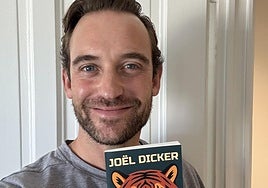 Joël Dicker idazlea, euskarara ekarri duten edizioarekin eskuetan.