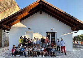 Foto de familia ante la escuela renovada en Saldias.