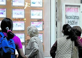 Varias personas observan el escaparate de una inmobiliaria esta semana en Donostia.