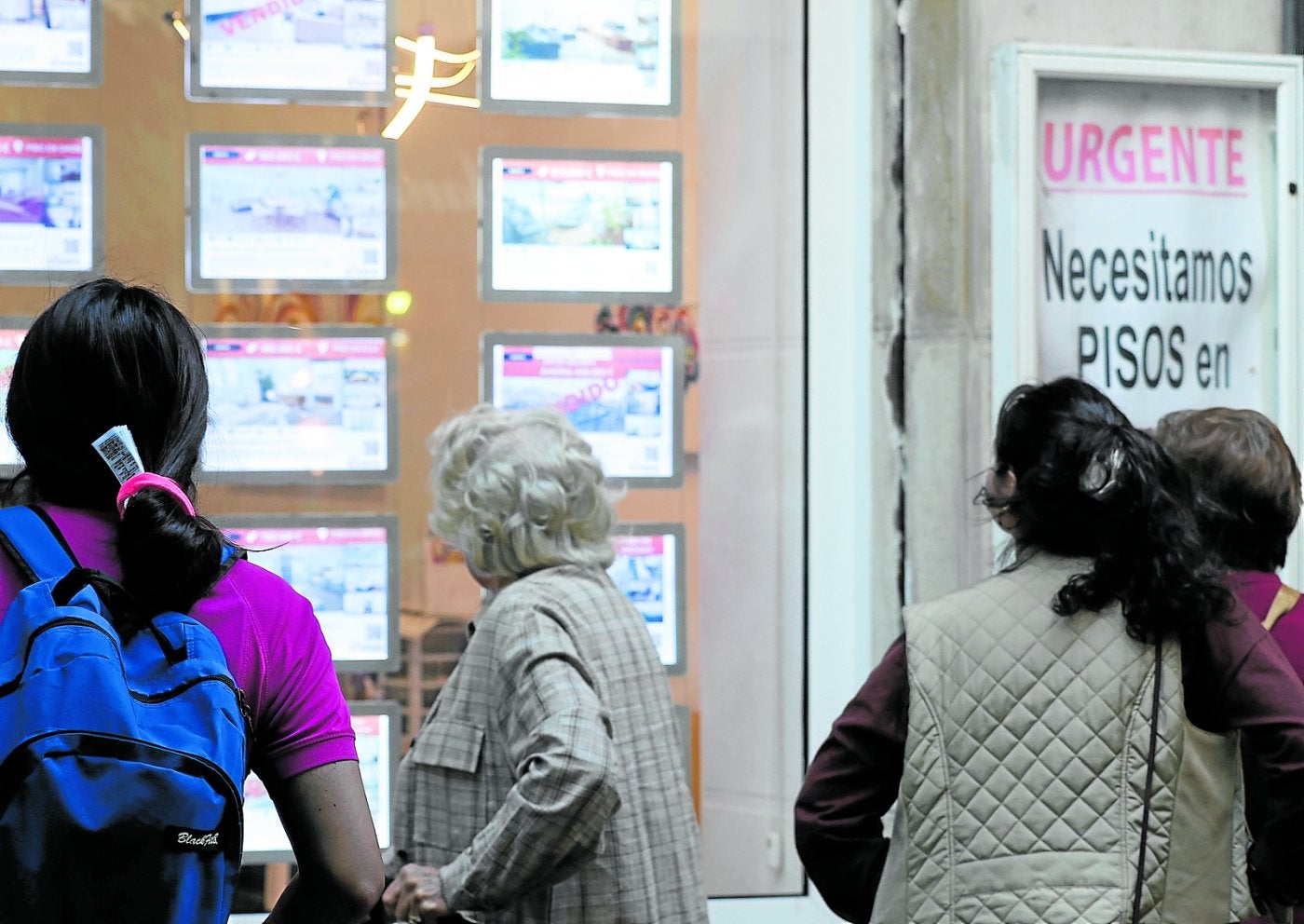 Varias personas observan el escaparate de una inmobiliaria esta semana en Donostia.