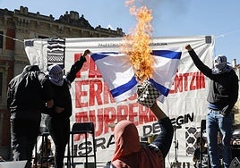 Manifestantes quemando la bandera de Israel