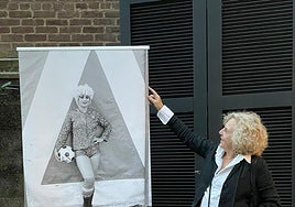 Azkarate, con su inseparable cámara, junto al cartel de la exposición.