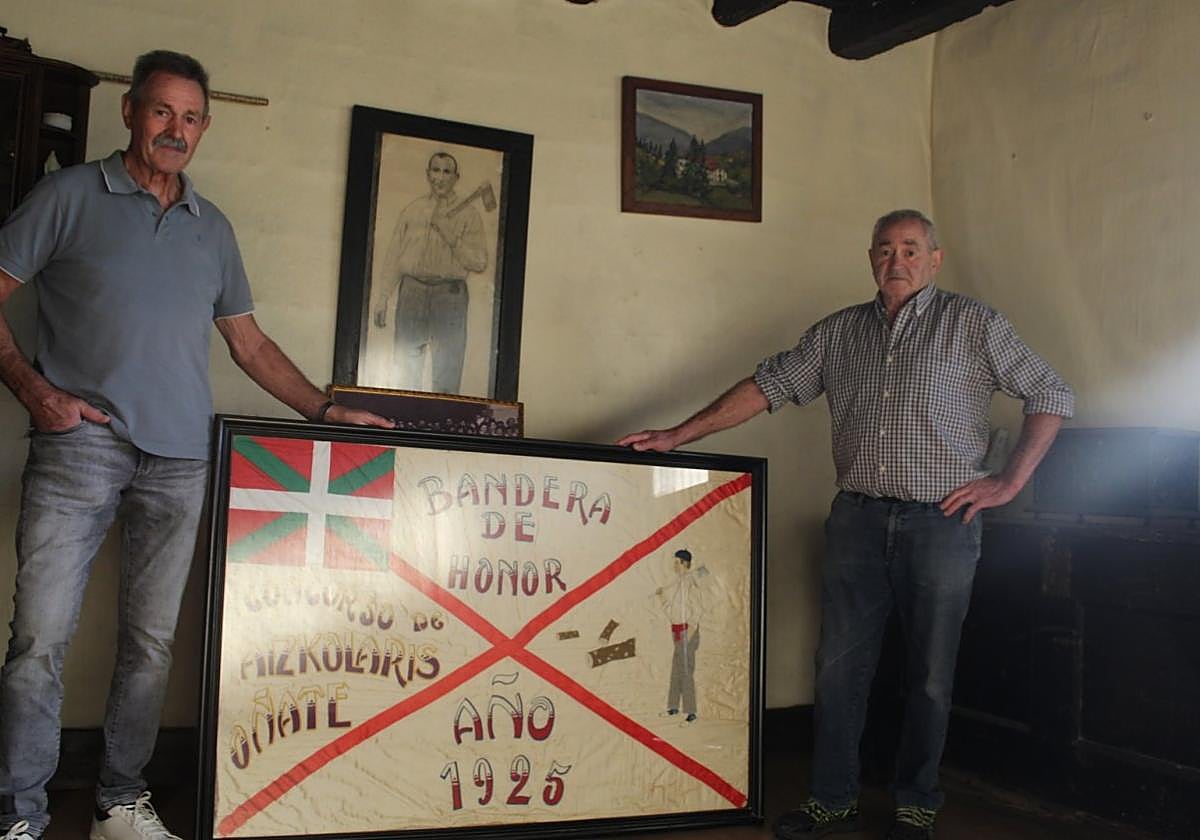 Julian eta Andres bilobak, 'Keixeta' baserrian aitonarekin bizitakoak, Oñatin irabazitako bandera eraberrituarekin.