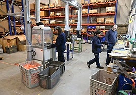 Dos operarias y un operario supervisan el producto de una empresa guipuzcoana.