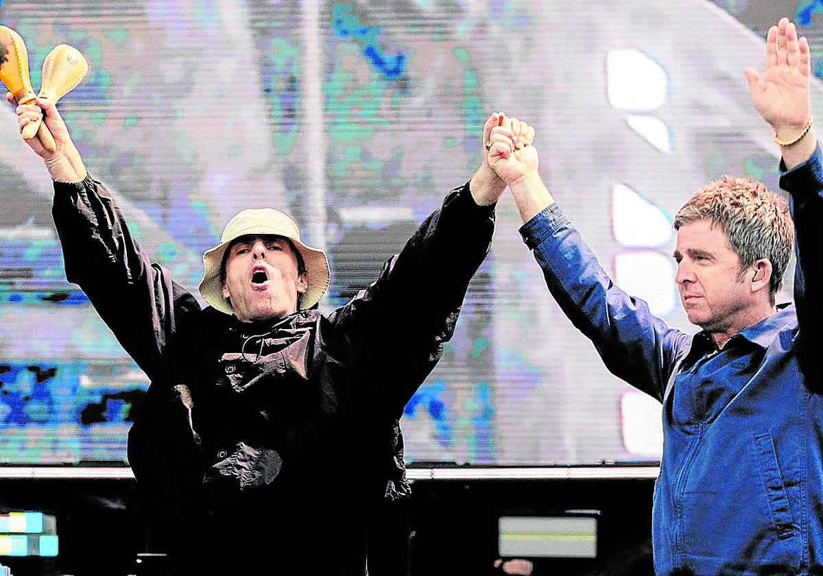 Los hermanos Gallagher saludan al público al término de su concierto en Manchester.