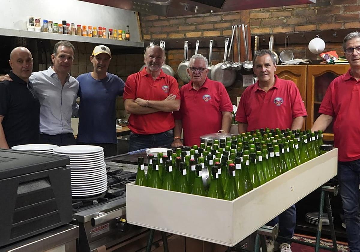La tradicional foto de familia de los organizadores con la sidra.