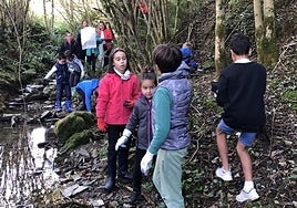Un grupo de niños y niñas junto a adultos durante al limpieza el año pasado de otra tramo.