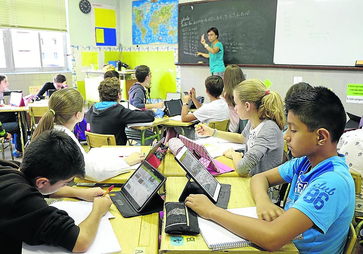 Varios alumnos utilizan tabletas en clase para seguir la explicación de su profesora.