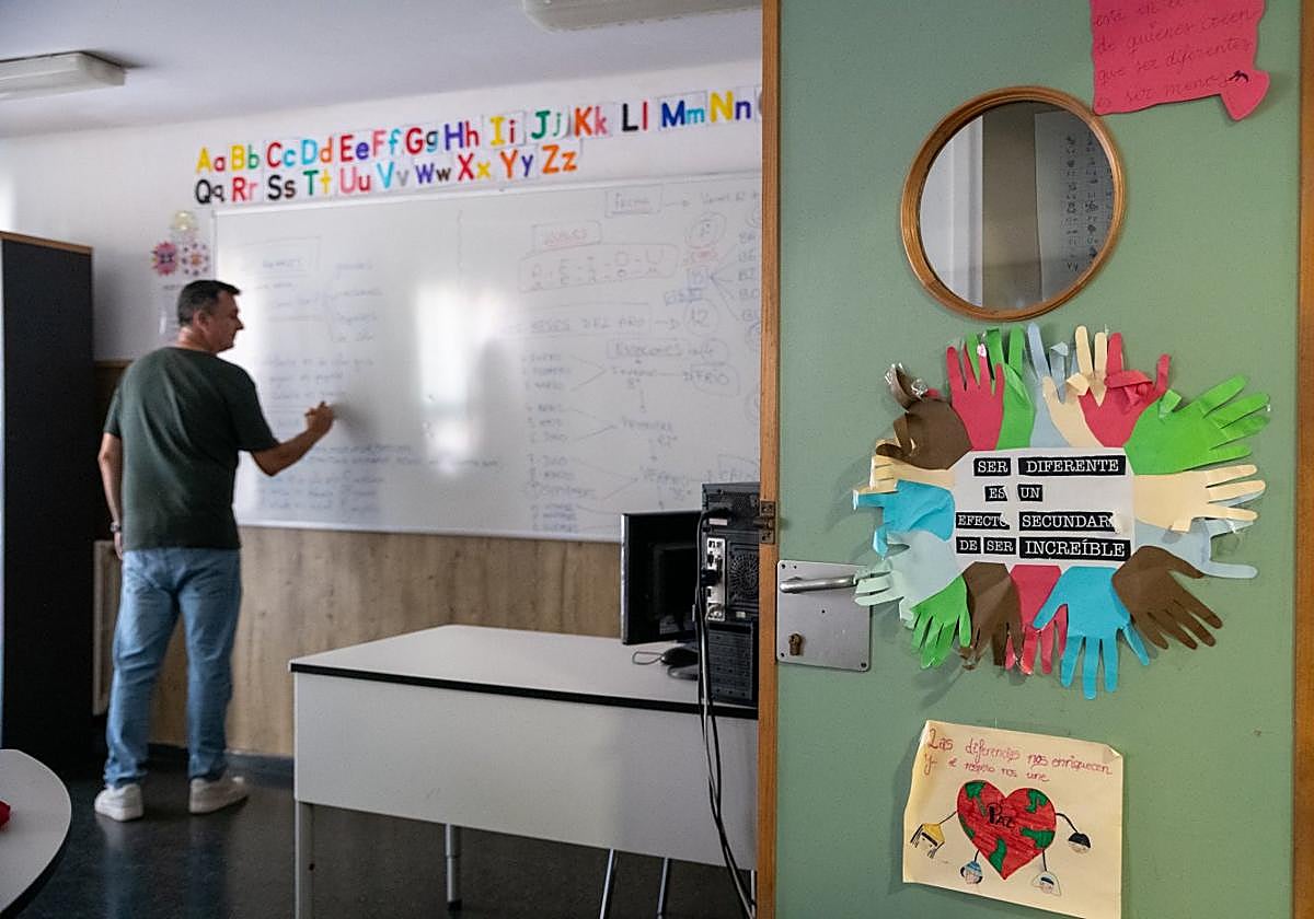 Un profesor apunta en la pizarra del aula de un colegio.