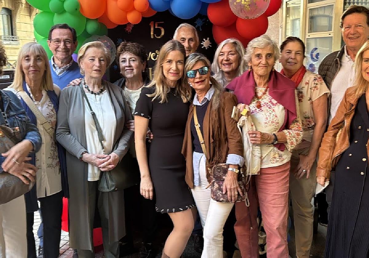 Alumnos y alumnas y familiares de la artista posan en la entrada de la academia, decorada con globos.