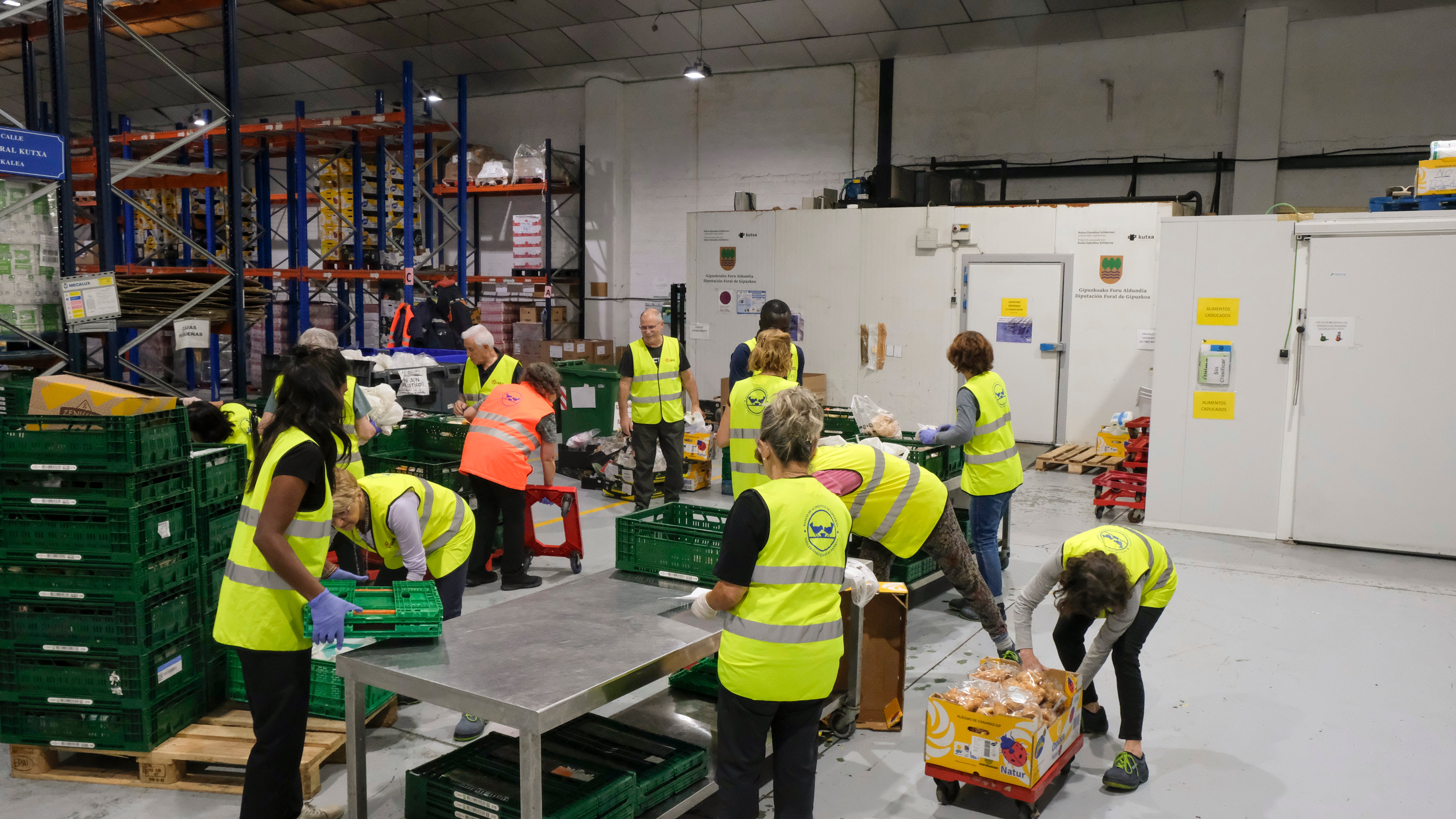 Voluntarios ayudan a descargar el alimento y a repartirlo por las diferentes estanterías que hay en el almacen.