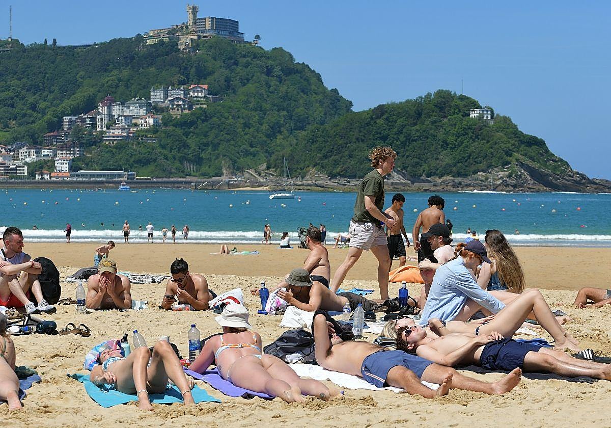 Un grupo de jóvenes toma el sol en la playa de La Concha de San Sebastián durant este último verano.