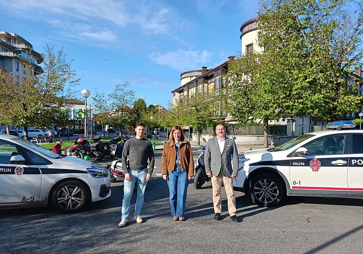 Sergio Javier, Cristina Laborda e Iñigo Bergés junto a vehículos de la policía municipal.
