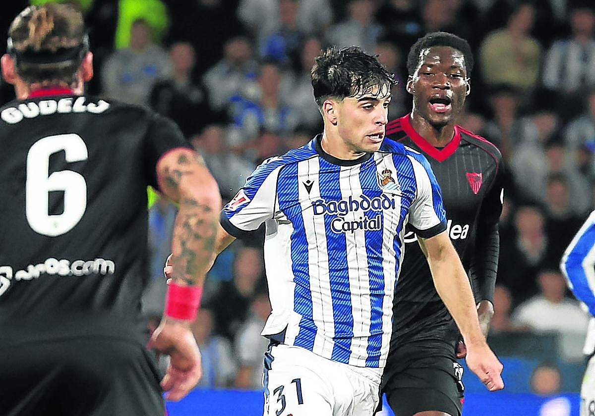 Jon Martín conduce el balón por delante de Agoumé, ayer en Anoeta.