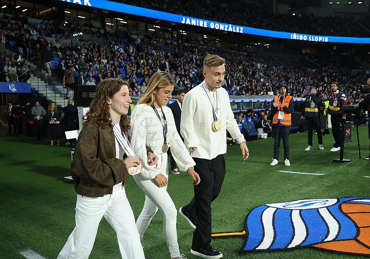 Nahia Zudaire, Janire González Etxabarri e Iñigo Llopis, camino del centro del campo de Anoeta para ser homenajeados.
