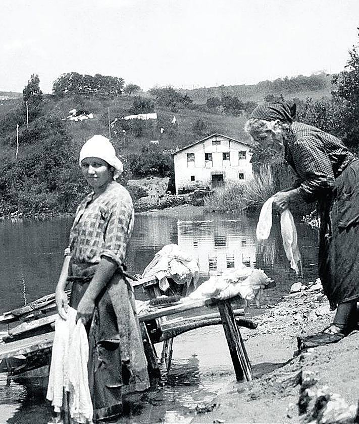 Imagen secundaria 2 - En la primera foto, Cuarteles y barrio de Loiola hacia 1940. En primer término: caserío Matxiñene, lavadero y frontón. En la segunda, Al son del txistu y tamboril en la 'billera de Loiola', junto a la casa Kapastegi. Al fondo el caserío Plazaburu o Galtzagorriene, en 1910. y en la última, lavanderas en el Urumea. Al fondo, caserío Bolagillene.