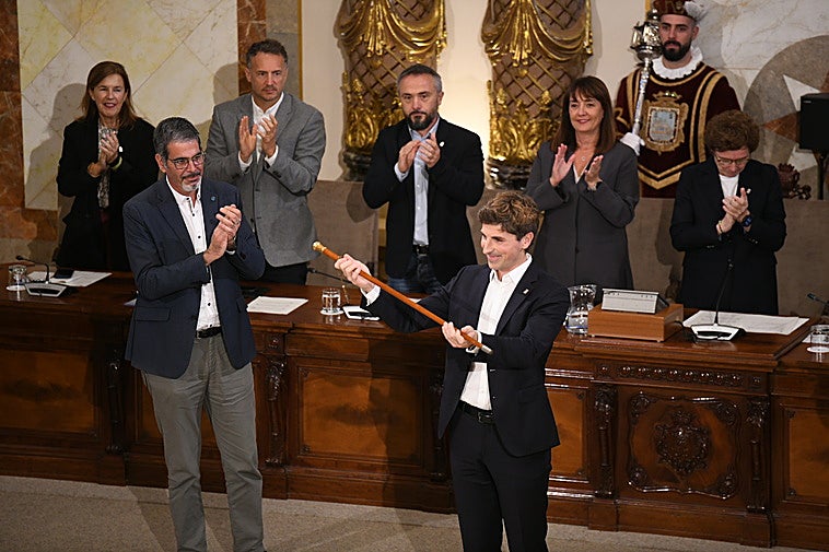 Jon Insausti recibe la makila de alcalde de Donostia de manos de Eneko Goia.