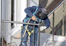 Un soldador trabaja en un piso en construcción ajeno a la información.