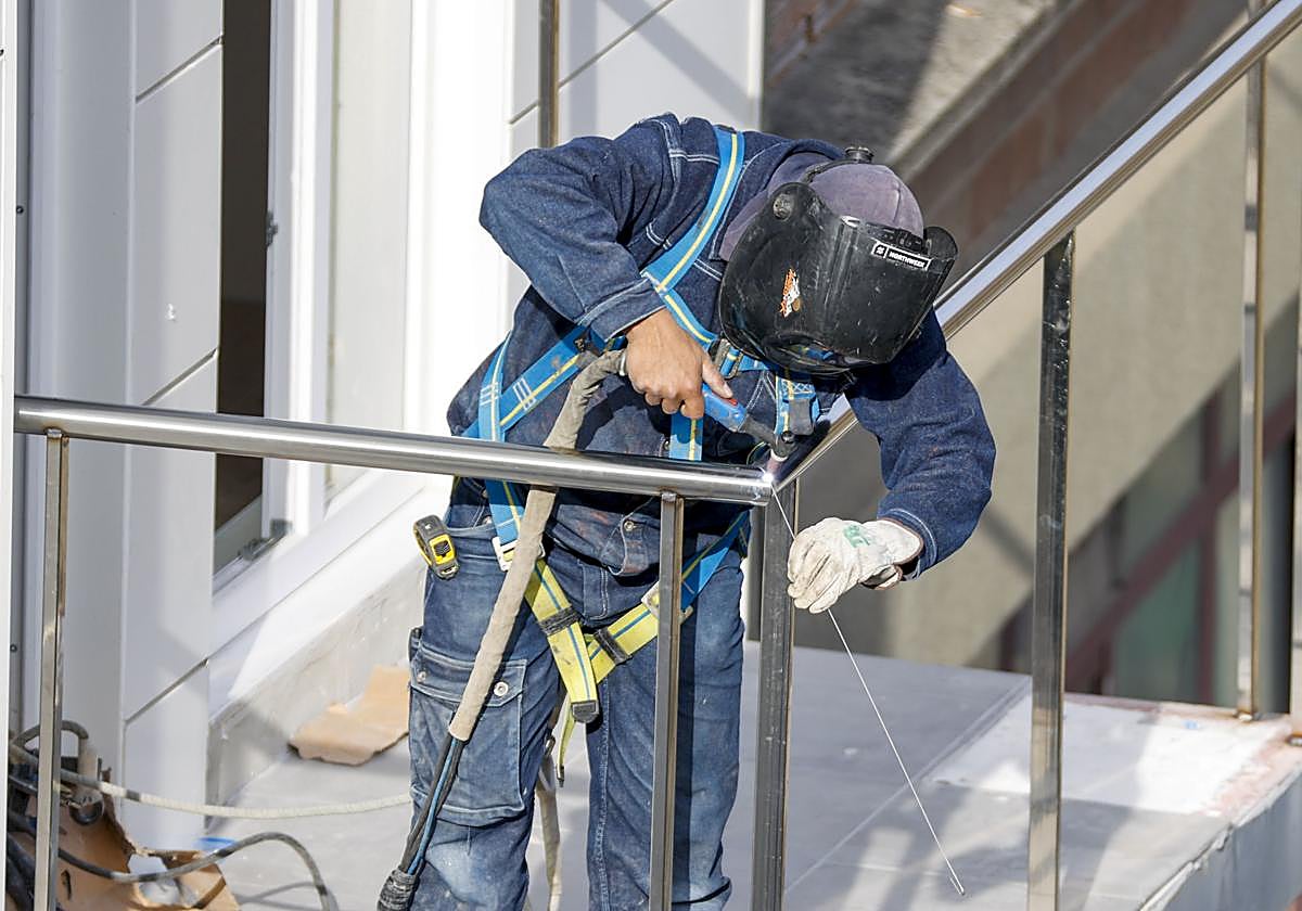 Un soldador trabaja en un piso en construcción ajeno a la información.