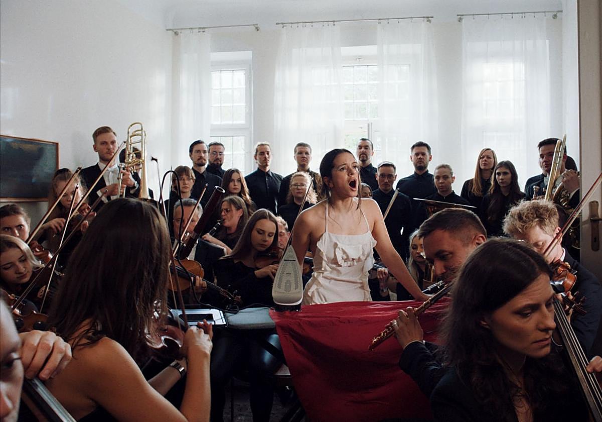 La Orquesta Sinfónica de Londres y miembros de los coros de la Escolanía de Montserrat y el Orfeó Català rodean a la cantante en un momento del nuevo clip.