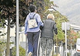 Una mujer ayuda a caminar a una persona mayor en una localidad guipuzcoana.