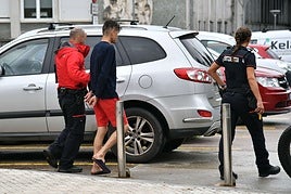 Dos ertzainas trasladan a un detenido en las inmediaciones del Hospital Donostia.