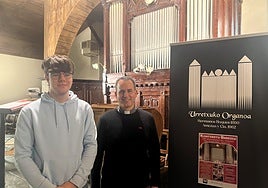 El joven organista Oier Gastón y el párroco Iban Munilla, ante el 'pequeño gran' órgano de San Martín de Tours.