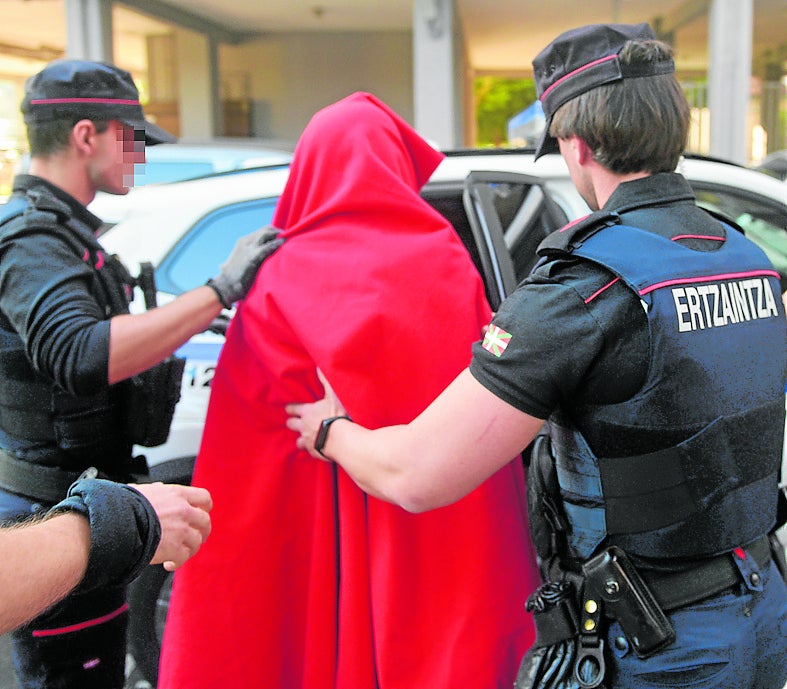 Dos ertzainas trasladan a un detenido a los juzgados de Donostia.