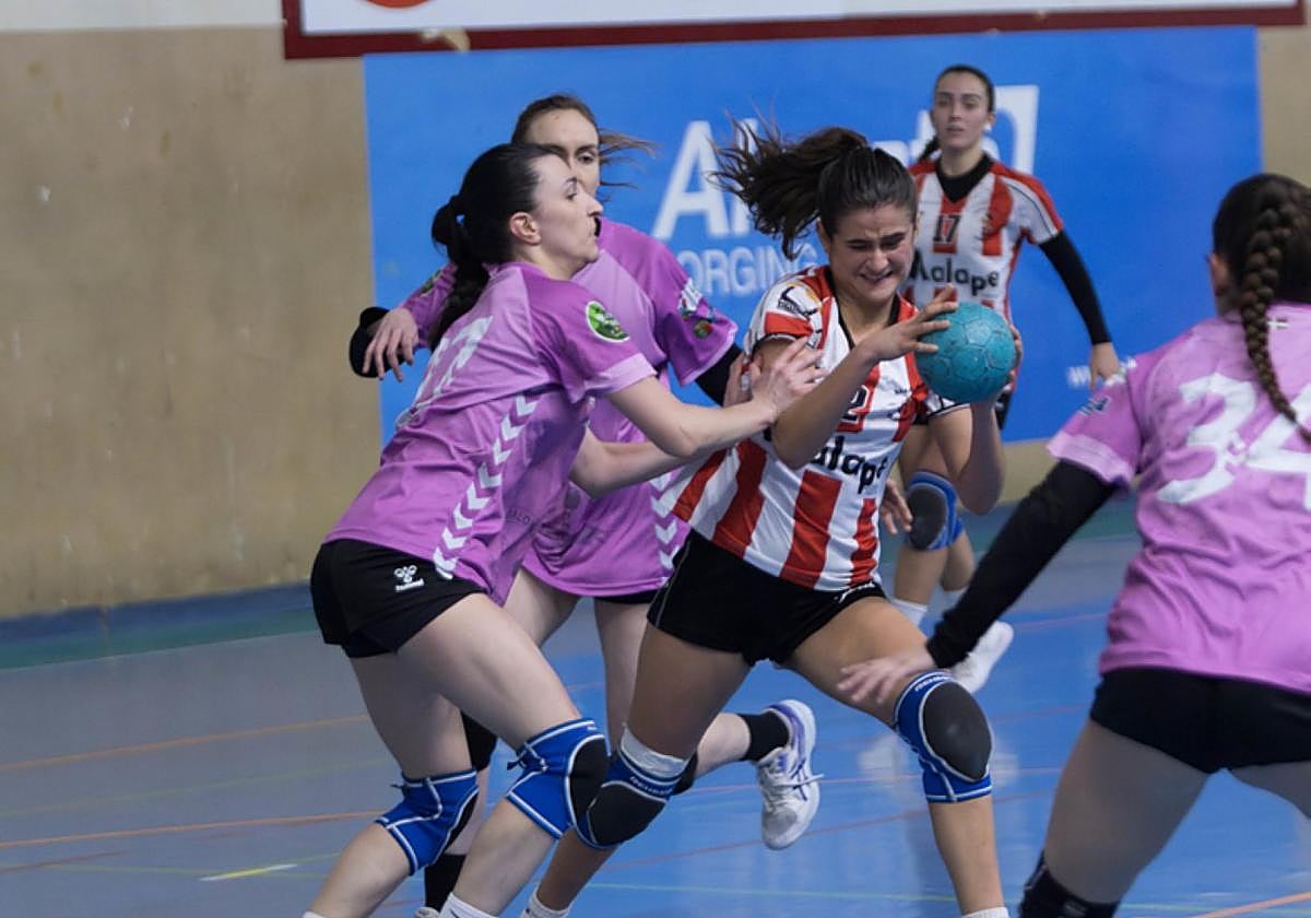 Una jugadora del Malape intenta zafarse de sus rivales.