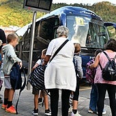 Varios niños se disponen a subirse a un bus escolar en Eibar.