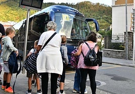 Varios niños se disponen a subirse a un bus escolar en Eibar.