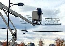 Un operario municipal instala alumbrado de Navidad en Azkuene.