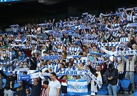 Los aficionados de la Real alzan las bufandas durante el himno txuri-urdin antes del inicio del partido.