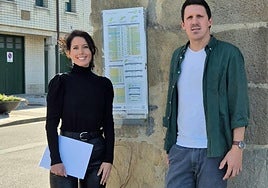 La diputada Azahara Domínguez con el alcalde de Aia, Jon Ander Azpiroz, junto al cartel de los horarios que Lurraldebus presta en Aia.